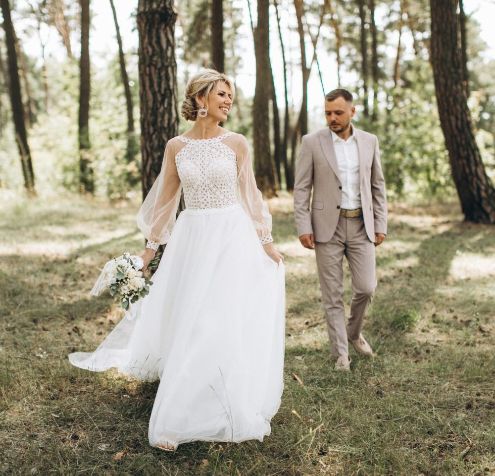 Wedding,Couple,Bride,And,Groom,Walk,In,Pine,Forest,,Sunlight